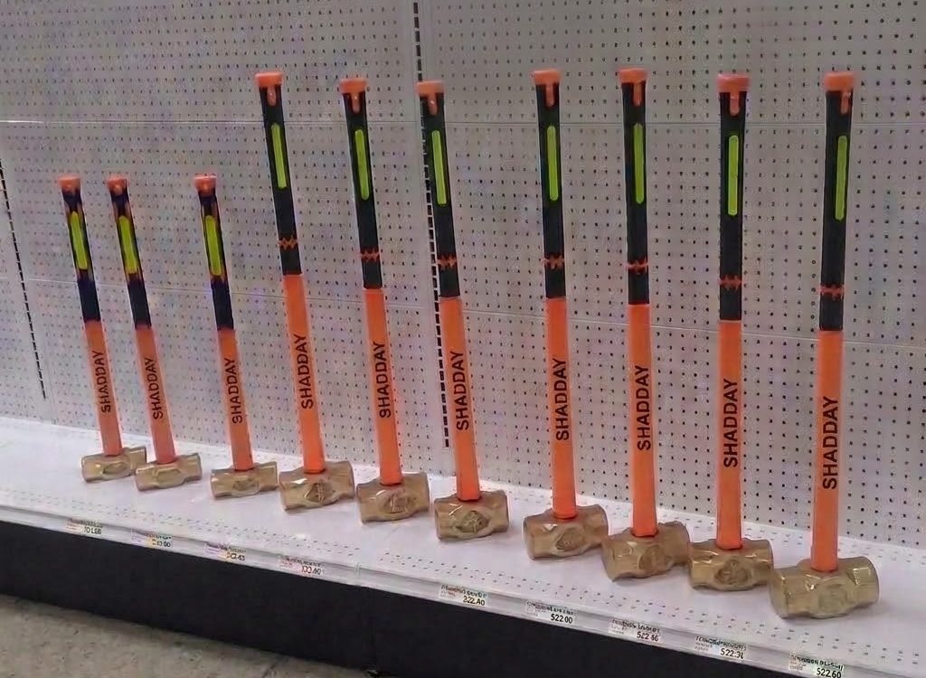 Fila de mandarrias Shadday con mango naranja exhibidas en el anaquel de una ferretería